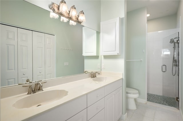 bathroom featuring tile patterned floors, vanity, toilet, and a shower with door