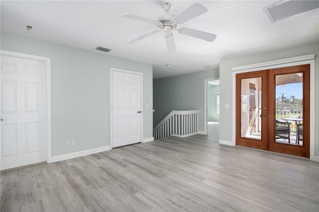 empty room with french doors, light wood-type flooring, and ceiling fan