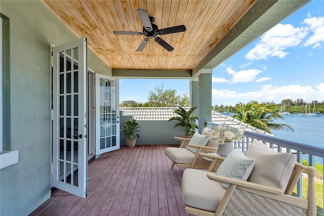 wooden terrace with ceiling fan and a water view