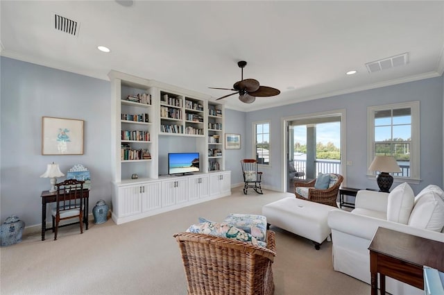 carpeted living room with ceiling fan and ornamental molding