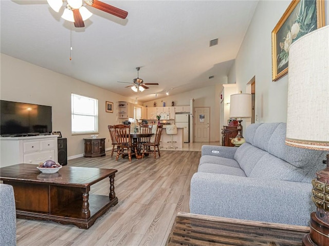 living area with lofted ceiling, ceiling fan, light wood-style flooring, and visible vents