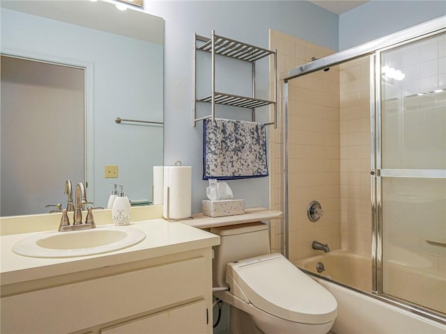 full bathroom featuring enclosed tub / shower combo, vanity, and toilet