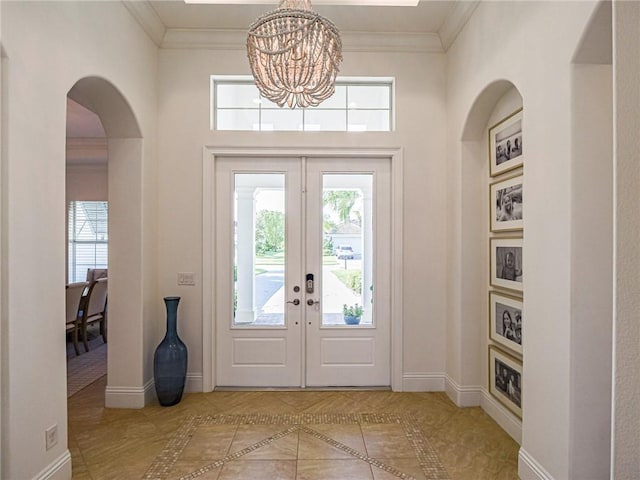 4520 Jacqueline Mnr, Vero Beach, FL 32968 - entryway with a chandelier, inlaid floor details, french doors, ornamental molding, and arched walkways