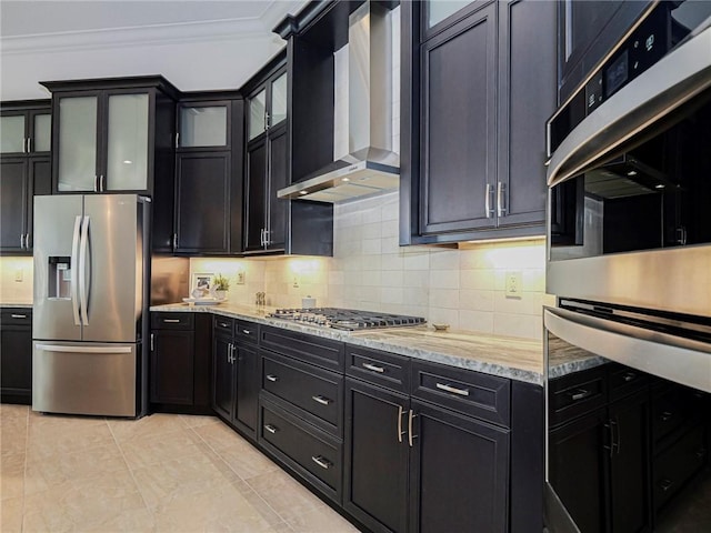 4520 Jacqueline Mnr, Vero Beach, FL 32968 - kitchen with stainless steel appliances, wall chimney exhaust hood, crown molding, decorative backsplash, and light stone counters