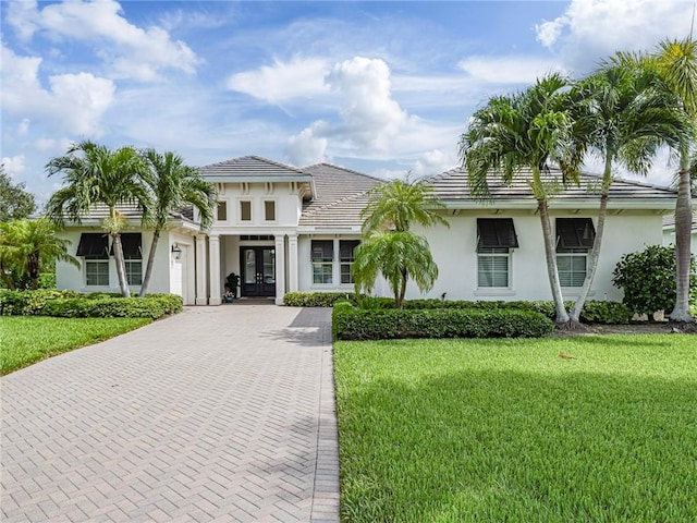 4520 Jacqueline Mnr, Vero Beach, FL 32968 - view of front of house featuring french doors, stucco siding, and a front lawn