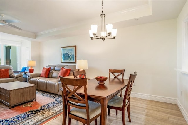 1510 Oak Harbor Blvd Unit 102, Vero Beach, FL 32967 - dining room with a chandelier, light wood-type flooring, a tray ceiling, ornamental molding, and baseboards