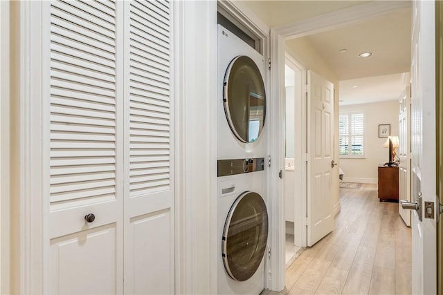 1510 Oak Harbor Blvd Unit 102, Vero Beach, FL 32967 - laundry room featuring stacked washing machine and dryer, recessed lighting, light wood-style flooring, and baseboards