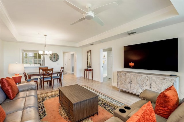 1510 Oak Harbor Blvd Unit 102, Vero Beach, FL 32967 - living room with a raised ceiling, light wood finished floors, a chandelier, and a ceiling fan