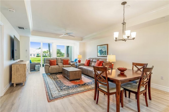 1510 Oak Harbor Blvd Unit 102, Vero Beach, FL 32967 - dining area featuring a raised ceiling, light wood-style floors, a chandelier, ceiling fan, and baseboards