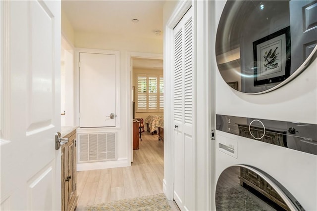 1510 Oak Harbor Blvd Unit 102, Vero Beach, FL 32967 - laundry room featuring stacked washing machine and dryer and light wood-type flooring