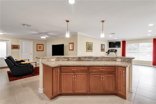 kitchen featuring crown molding, a center island, hanging light fixtures, light tile patterned floors, and a textured ceiling