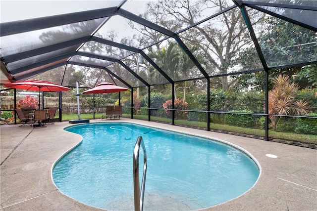 view of pool featuring glass enclosure and a patio area