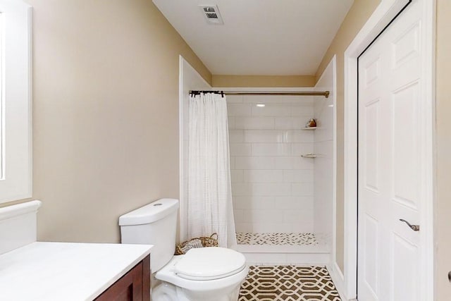 bathroom with vanity, tile patterned flooring, curtained shower, and toilet