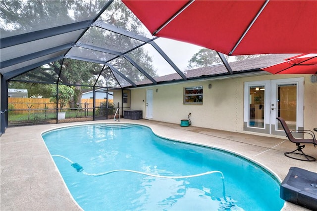 view of swimming pool with a lanai, a patio, and french doors