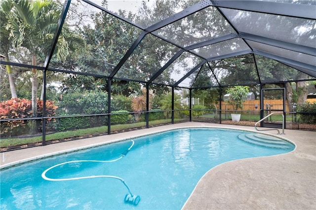 view of swimming pool featuring a patio and glass enclosure