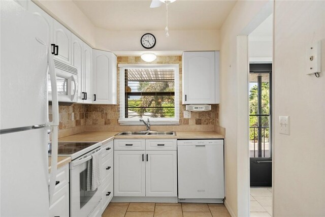 kitchen featuring white cabinetry, sink, white appliances, and light tile patterned flooring