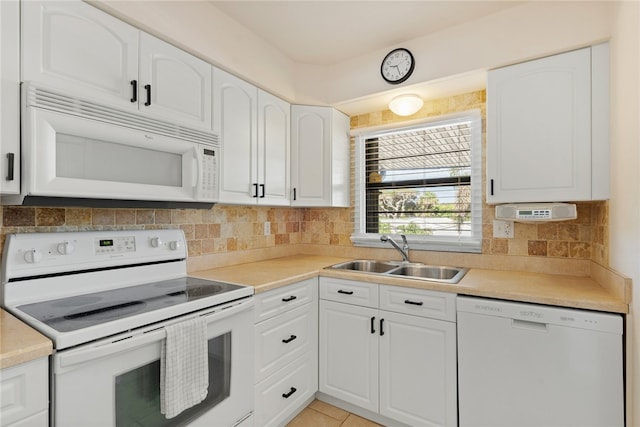 kitchen featuring white appliances, white cabinetry, sink, and backsplash