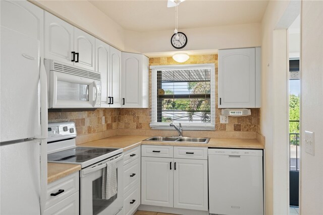 kitchen featuring decorative backsplash, white appliances, sink, and white cabinets