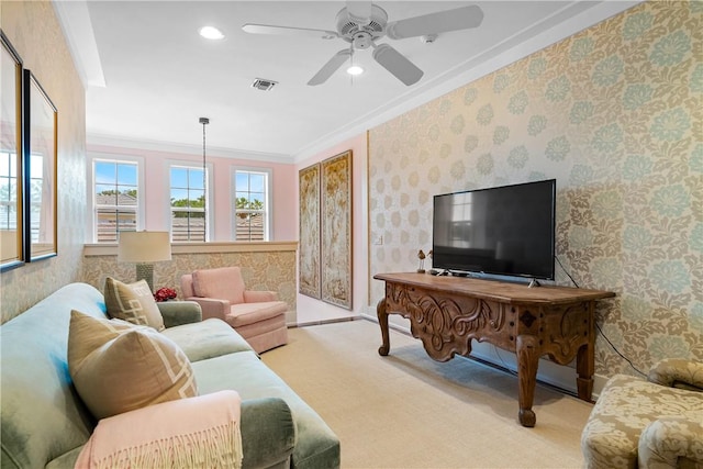 carpeted living room with ceiling fan and ornamental molding