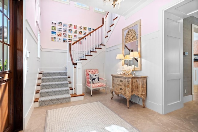 entrance foyer with light tile patterned floors and an inviting chandelier