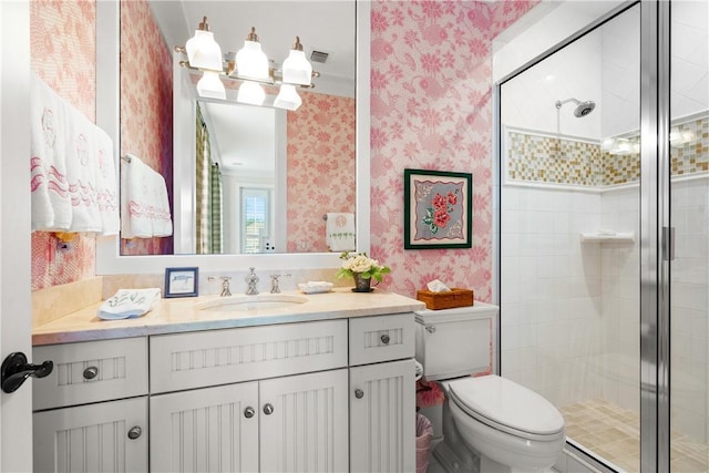 bathroom with vanity, a shower with shower door, and toilet