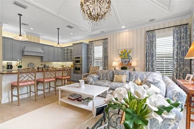 tiled living room with ornamental molding and a chandelier