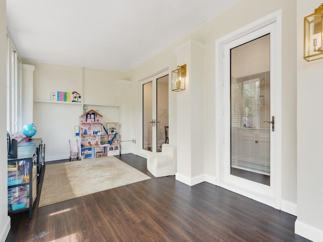 interior space with baseboards, dark wood-type flooring, and french doors