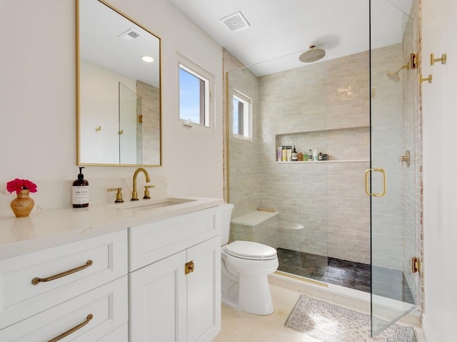 bathroom featuring toilet, vanity, a shower stall, and visible vents