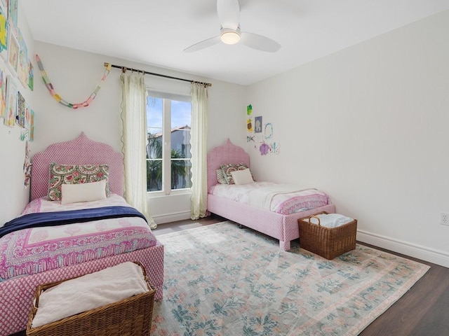 bedroom with a ceiling fan, baseboards, and wood finished floors