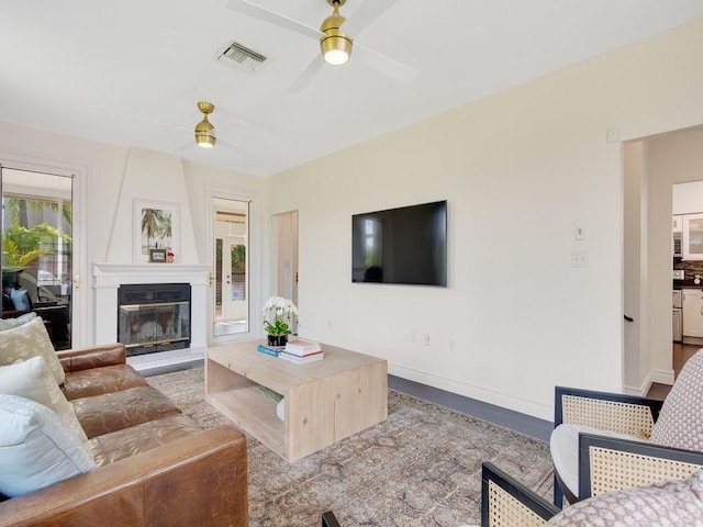 living room with baseboards, a fireplace, visible vents, and a ceiling fan