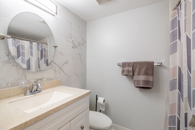 bathroom with walk in shower, vanity, toilet, and tasteful backsplash