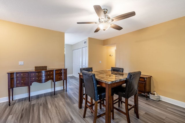 dining area featuring dark hardwood / wood-style flooring and ceiling fan