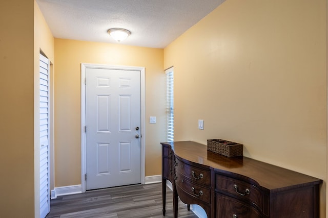 entrance foyer with dark wood-type flooring and a textured ceiling