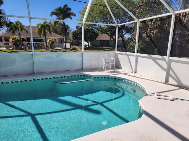 pool with a patio area and glass enclosure