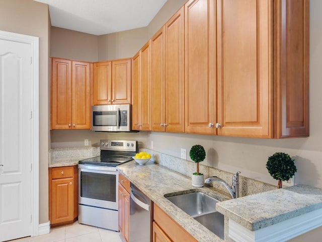 kitchen featuring sink, light tile patterned flooring, light stone countertops, and appliances with stainless steel finishes