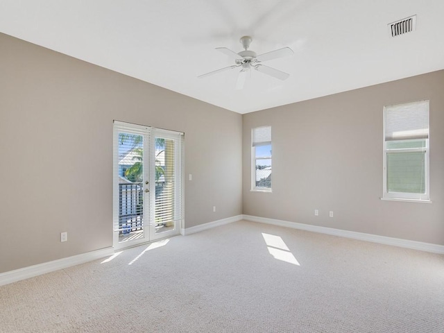 unfurnished room featuring ceiling fan, light colored carpet, and french doors