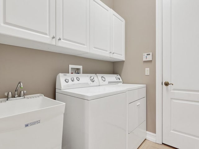 washroom with sink, cabinets, washer and dryer, and light tile patterned flooring