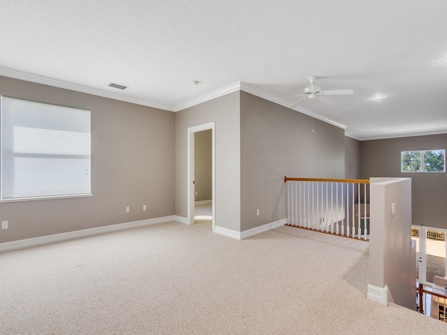 carpeted spare room featuring crown molding and ceiling fan