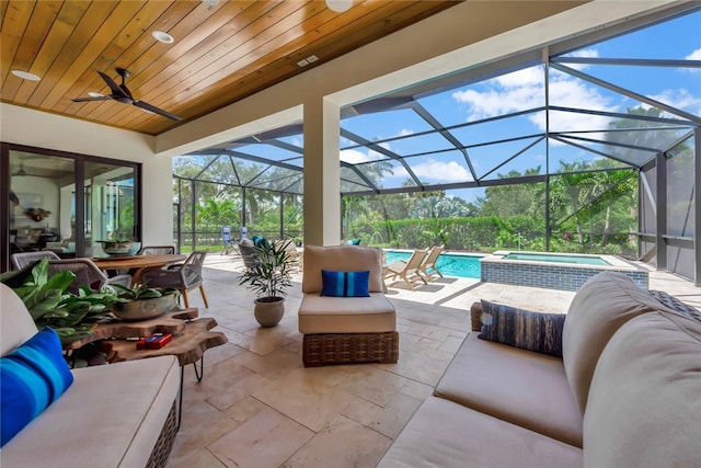 view of patio with a lanai, a swimming pool with hot tub, ceiling fan, and an outdoor living space