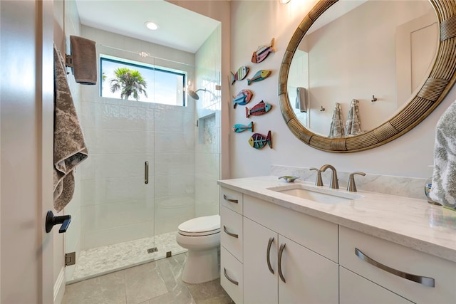 bathroom with vanity, toilet, and a shower with door