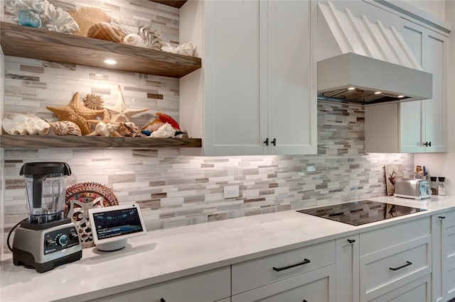 kitchen featuring white cabinetry, decorative backsplash, black electric stovetop, and custom exhaust hood