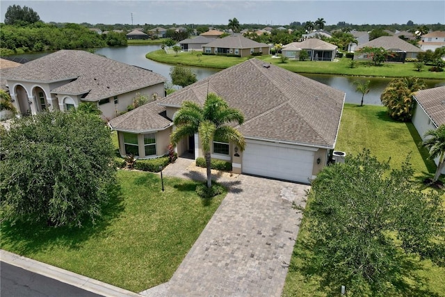 765 Fortunella Cir SW, Vero Beach, FL 32968 - view of front facade with a garage, a water view, driveway, a residential view, and a front lawn