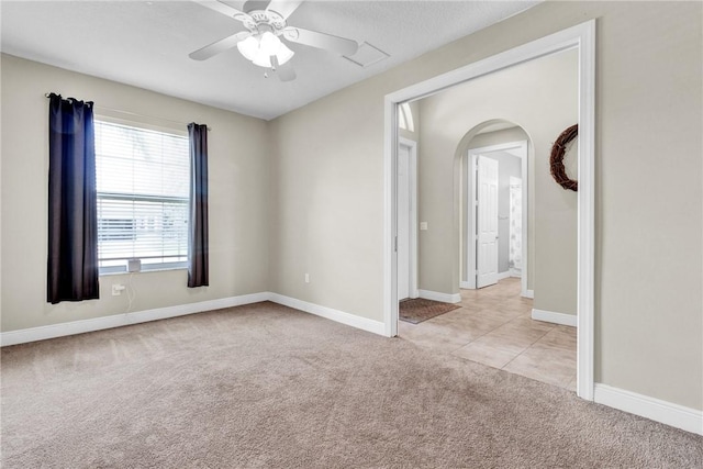 765 Fortunella Cir SW, Vero Beach, FL 32968 - unfurnished room with light carpet, arched walkways, a ceiling fan, baseboards, and light tile patterned flooring