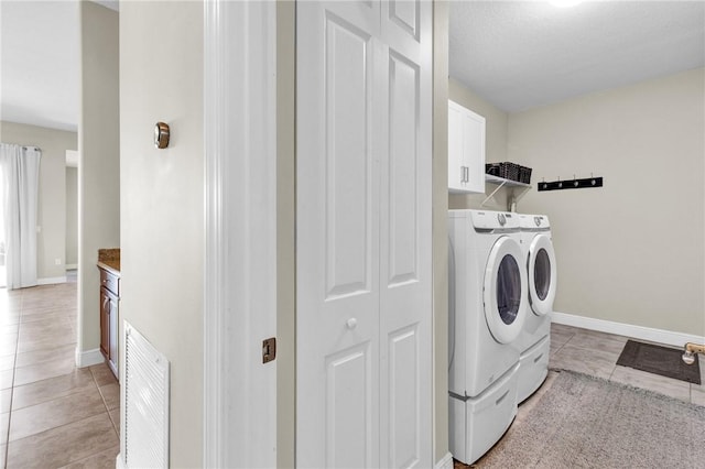 765 Fortunella Cir SW, Vero Beach, FL 32968 - laundry area with washing machine and clothes dryer, cabinet space, light tile patterned floors, and baseboards