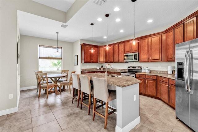 765 Fortunella Cir SW, Vero Beach, FL 32968 - kitchen featuring stainless steel appliances, a sink, light stone counters, recessed lighting, and brown cabinetry