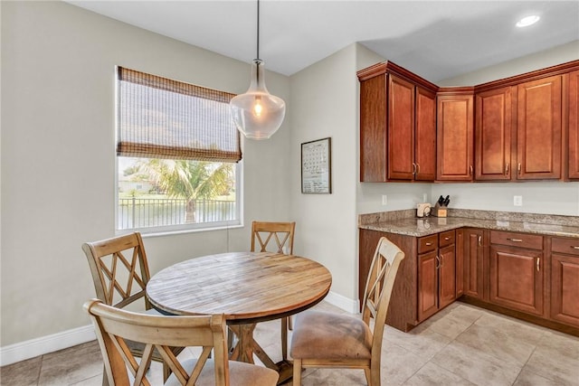 765 Fortunella Cir SW, Vero Beach, FL 32968 - kitchen featuring light stone counters, baseboards, light tile patterned floors, and hanging light fixtures