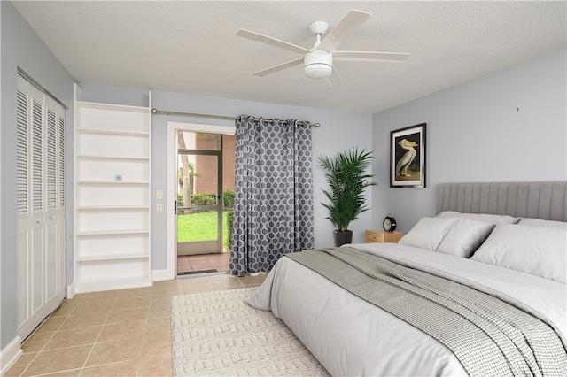 tiled bedroom featuring ceiling fan, a textured ceiling, and a closet