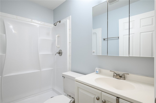 bathroom featuring a shower, vanity, and toilet