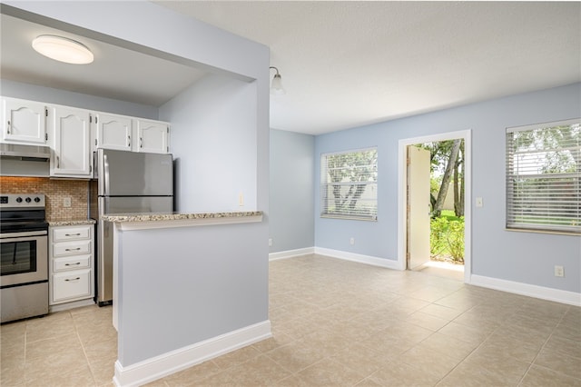 kitchen featuring white cabinetry, appliances with stainless steel finishes, light tile patterned floors, and backsplash