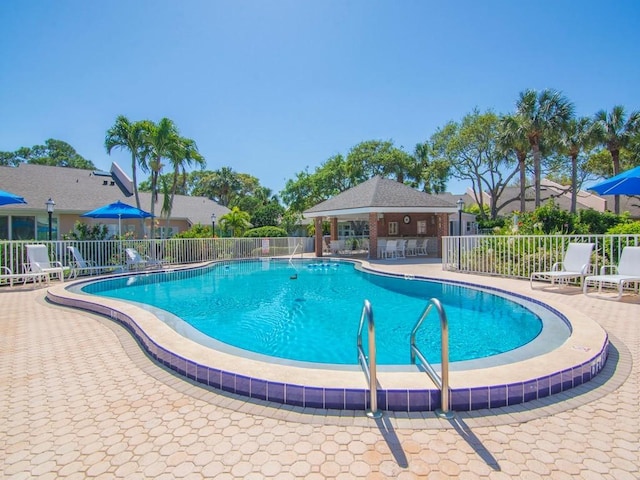 community pool featuring a patio area and fence